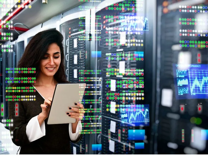 Woman in data center looking at tablet with many green and red dots